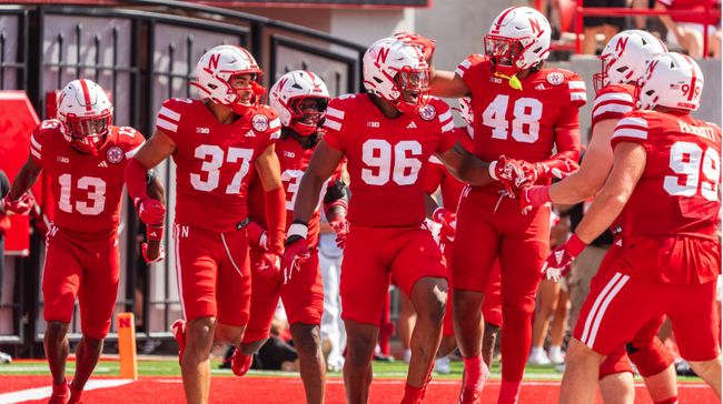 Nebraska football players celebrating in red uniforms
