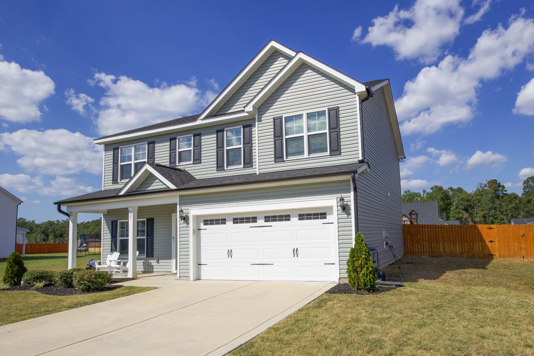 Front of 221 Vega Lane in Linden, NC, showing the covered porch, two-car garage and fenced side yard