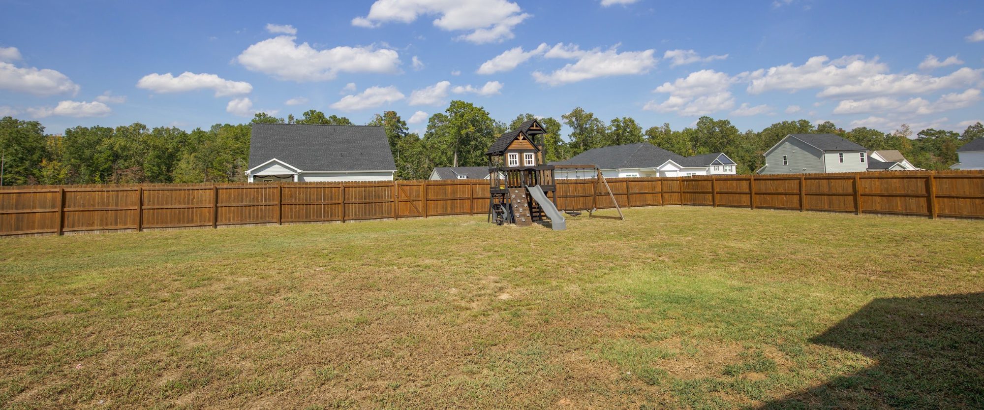 Fenced backyard with a playset at 221 Vega Lane