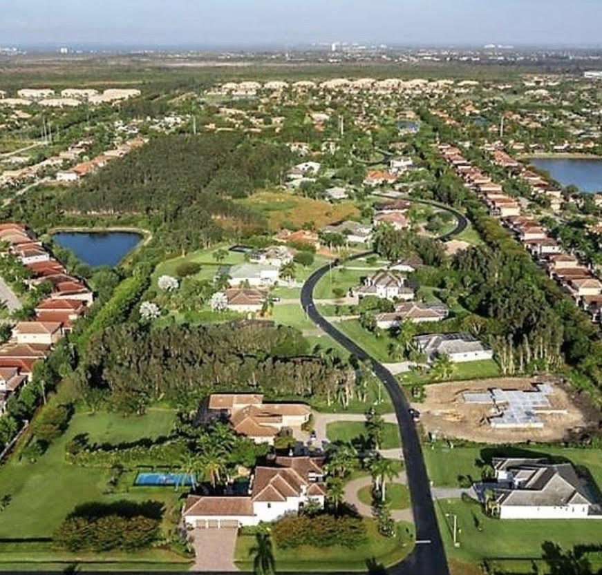 The image depicts an elegant luxury home exterior situated in a gated community, featuring mature landscaping and a circular driveway that enhances its curb appeal. This stunning property is a prime example of Belle Meade real estate in Fort Myers, Florida, showcasing the charm of dream homes for sale in the area.