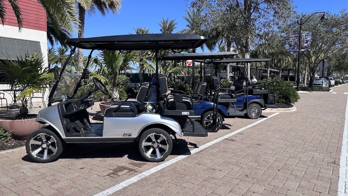 Golf carts near the Babcock Ranch town center with shops and walkable paths nearby.