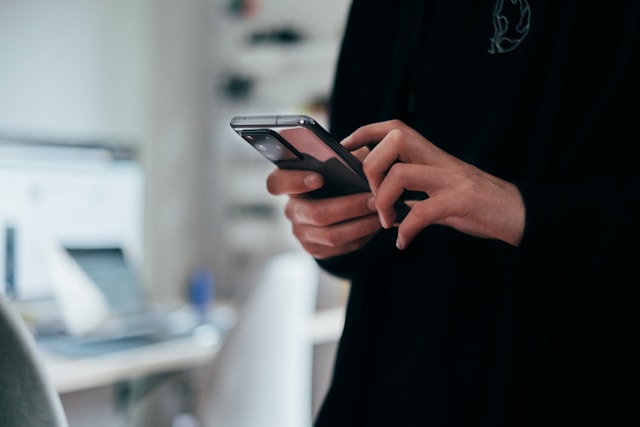 A woman scrolling on her phone looking at real estate social media posts