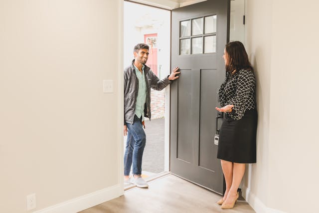 A female real estate agent giving a potential male buyer a home tour