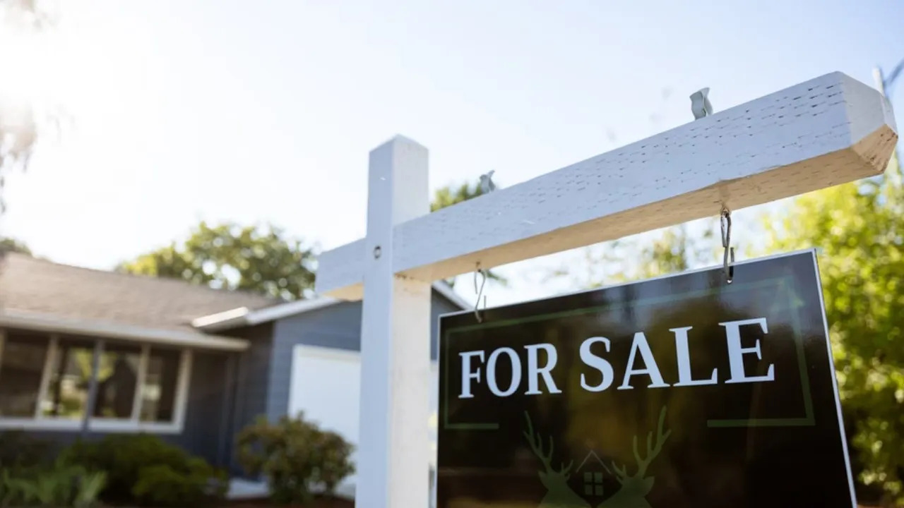 For sale” yard sign in front of a residential home in San Diego, showcasing the active San Diego housing market. Bright, sunny curb appeal highlights a single-family home in a desirable neighborhood, reflecting rising inventory and real estate opportunities in San Diego County.