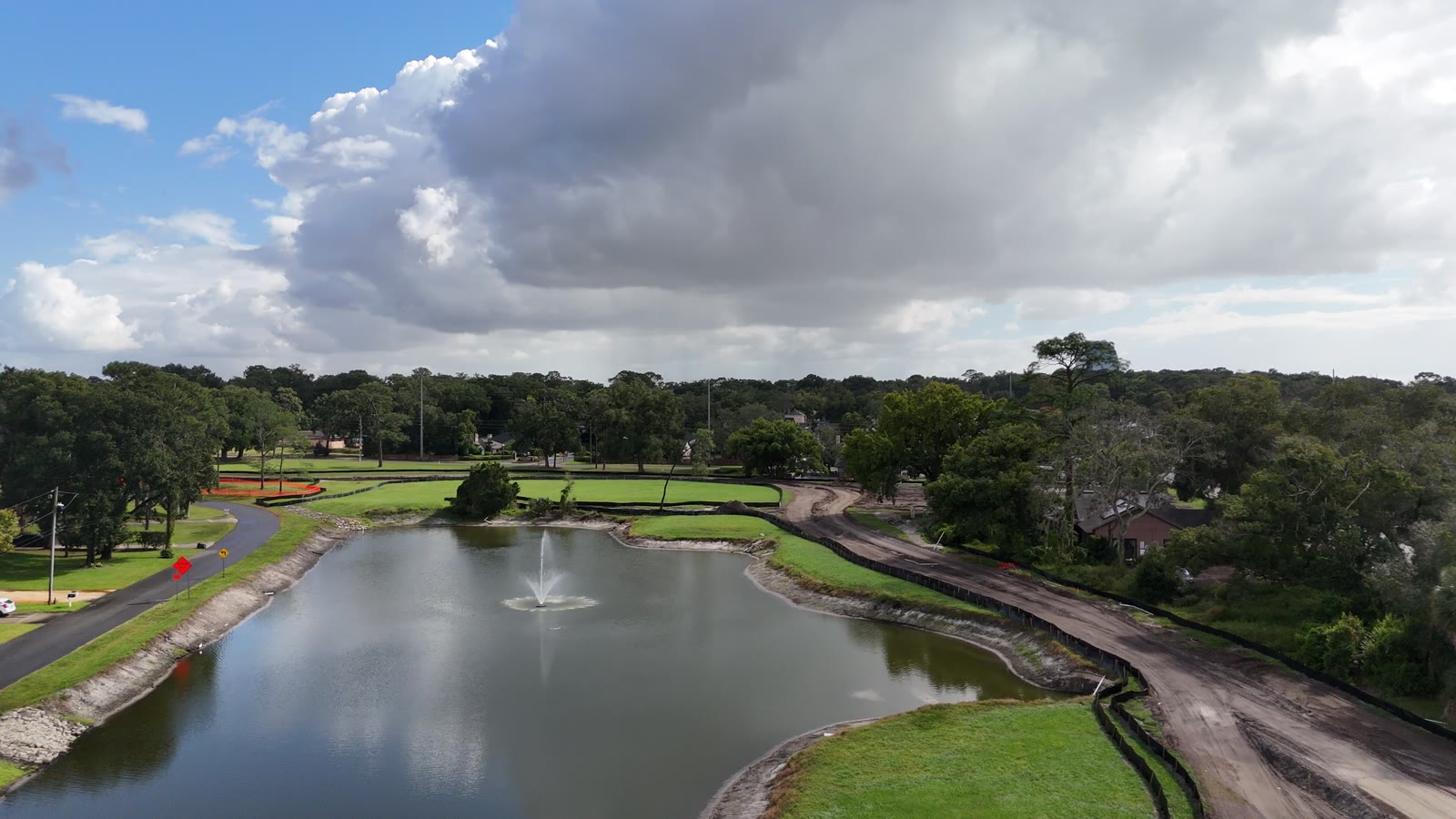 Rolling Hills Community Park construction, October 2026 Drone view of a pond with a fountain on the former Rolling Hills golf course in Longwood, with the new trail being graded beside it