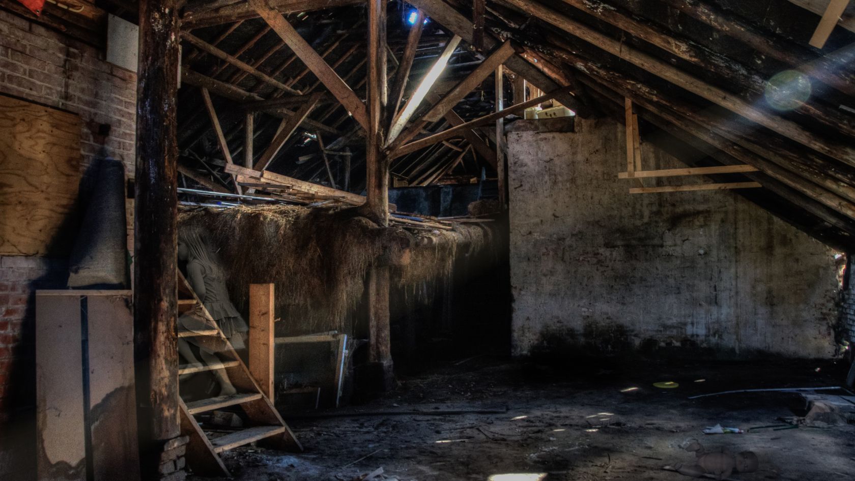 Dark attic with exposed beams and dust, suggesting deferred maintenance