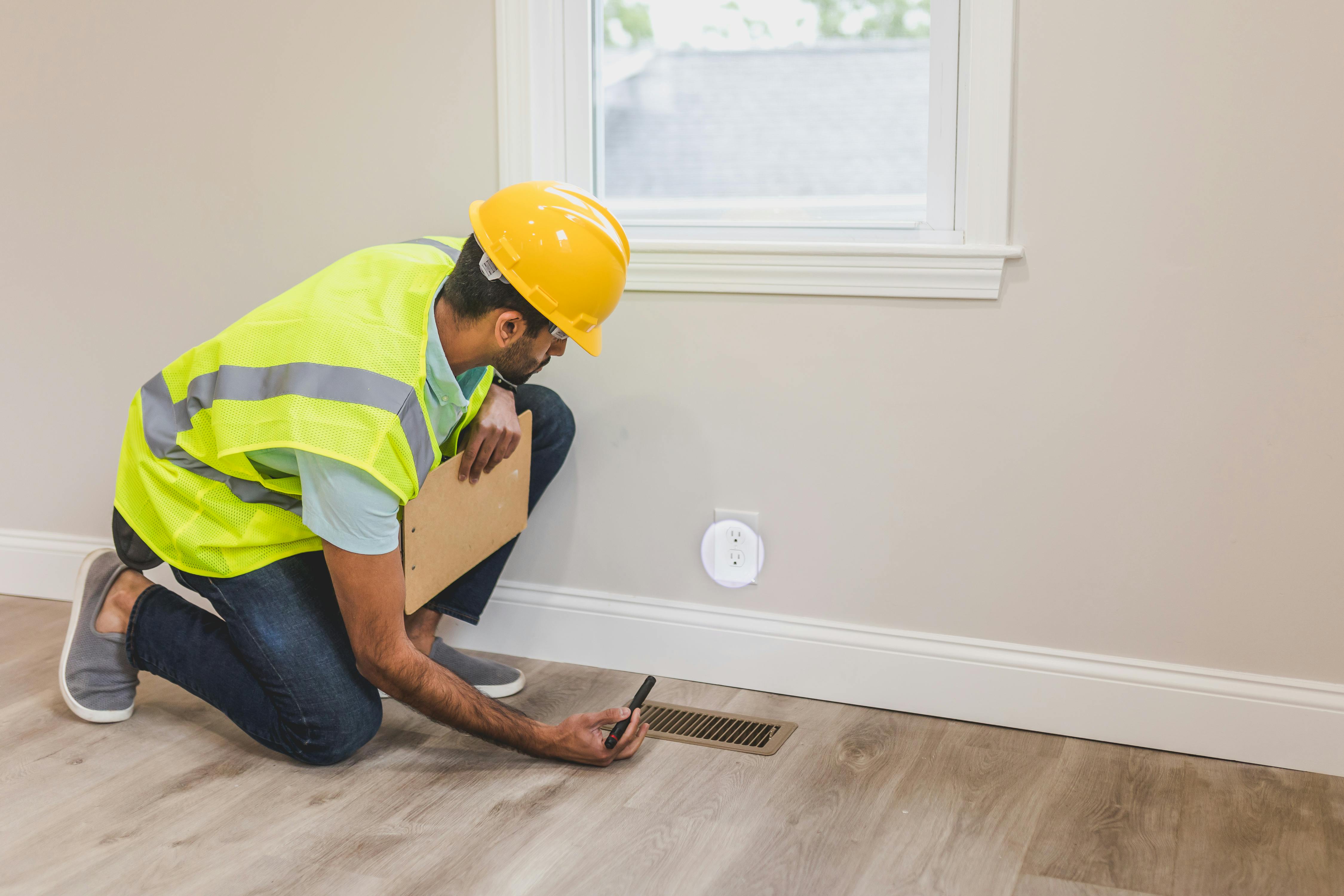 A couple standing with a real estate agent who points out details near a large window during a home walkthrough