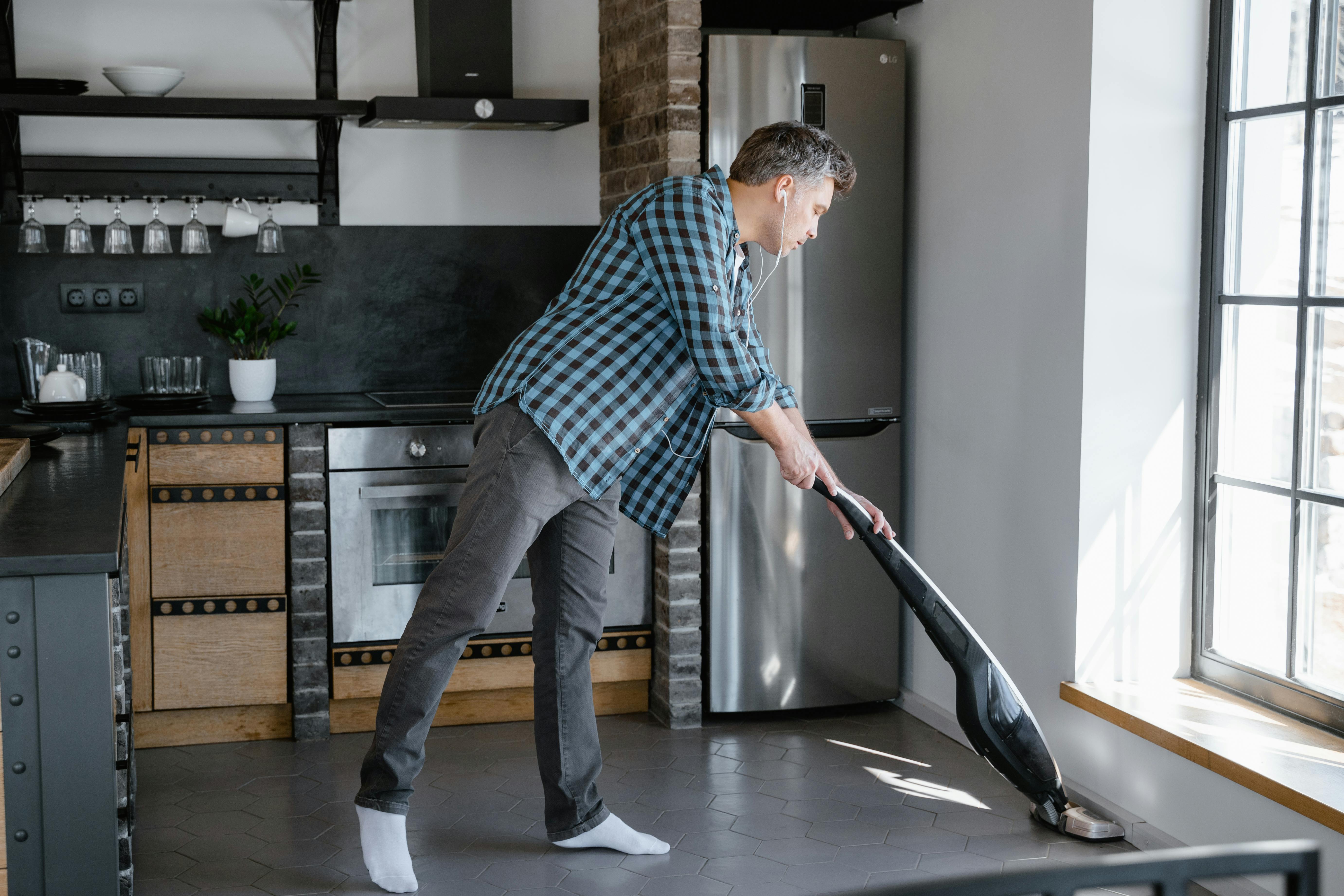 Man vacuuming the kitchen floor