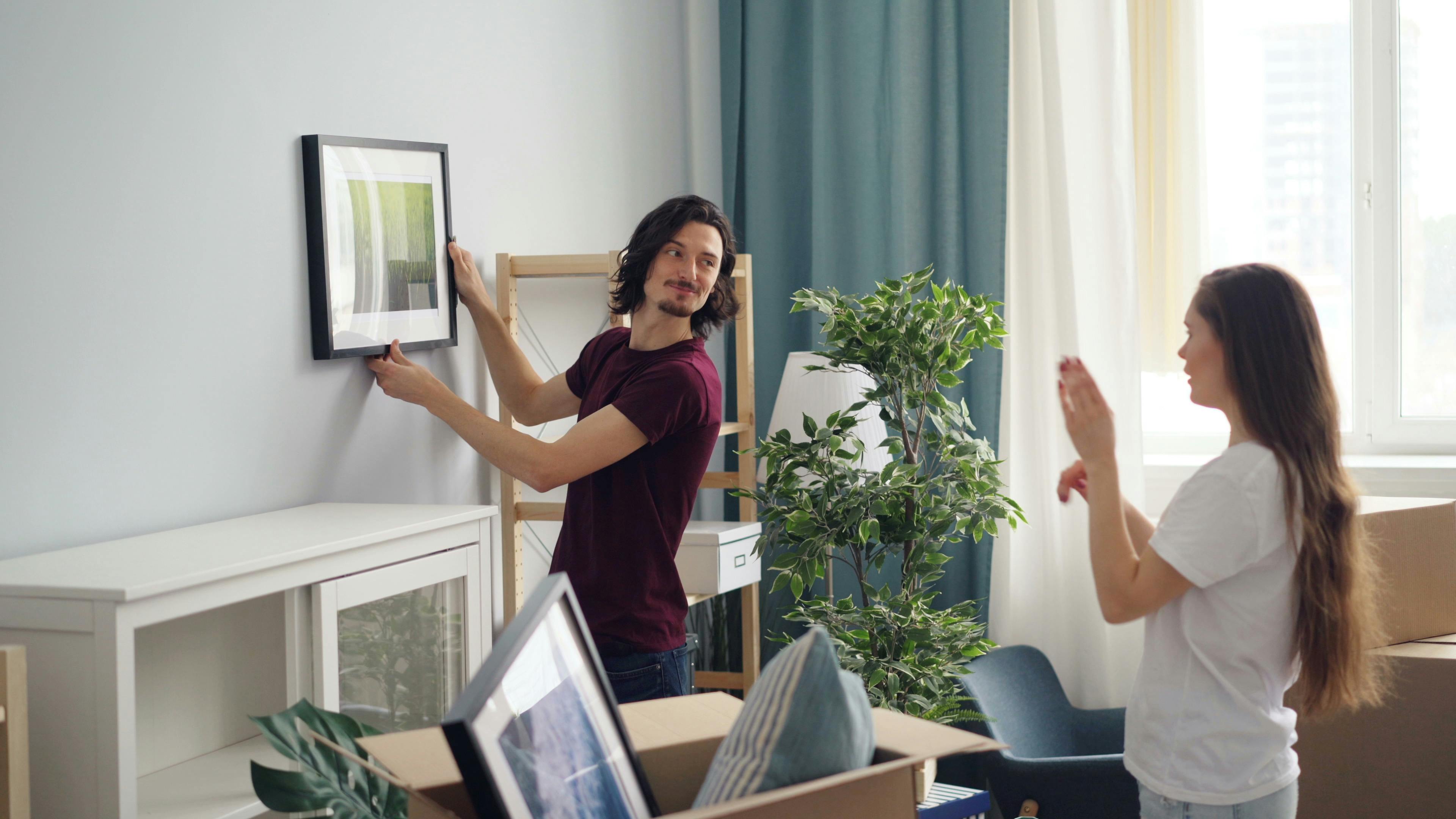 Couple hanging a picture on the wall in their new home