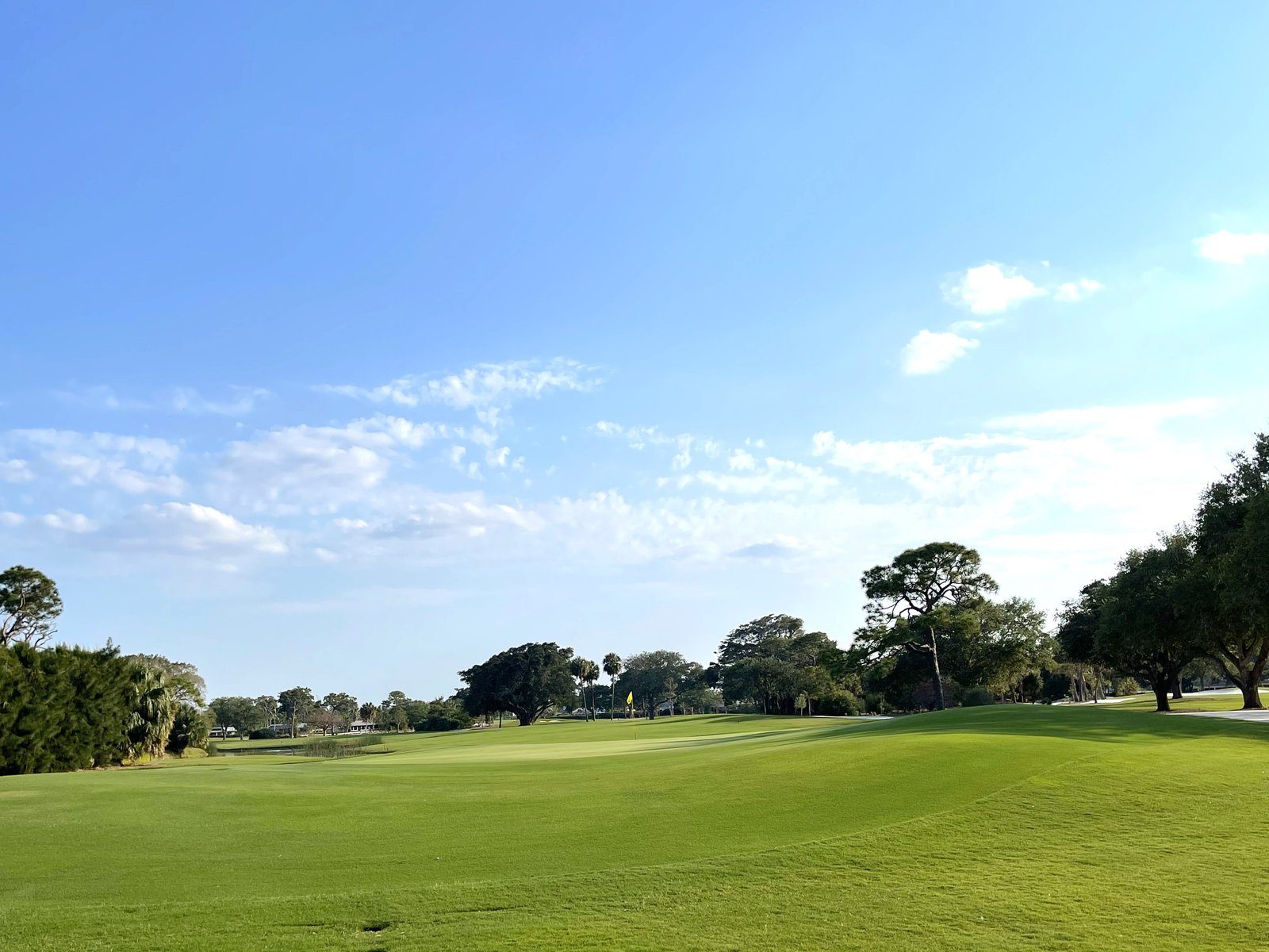 A golf fairway under a blue sky