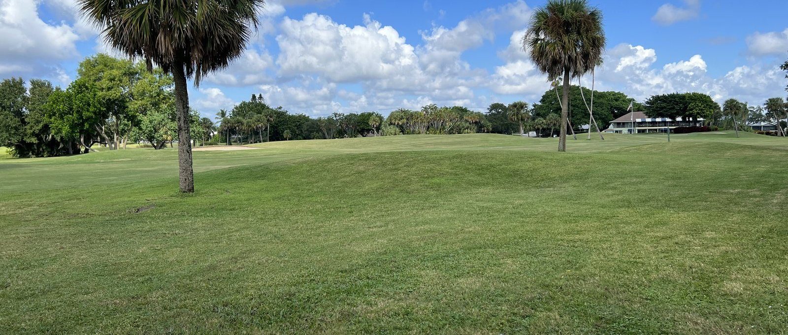 A golf course with a clubhouse in the distance near Hobe Sound