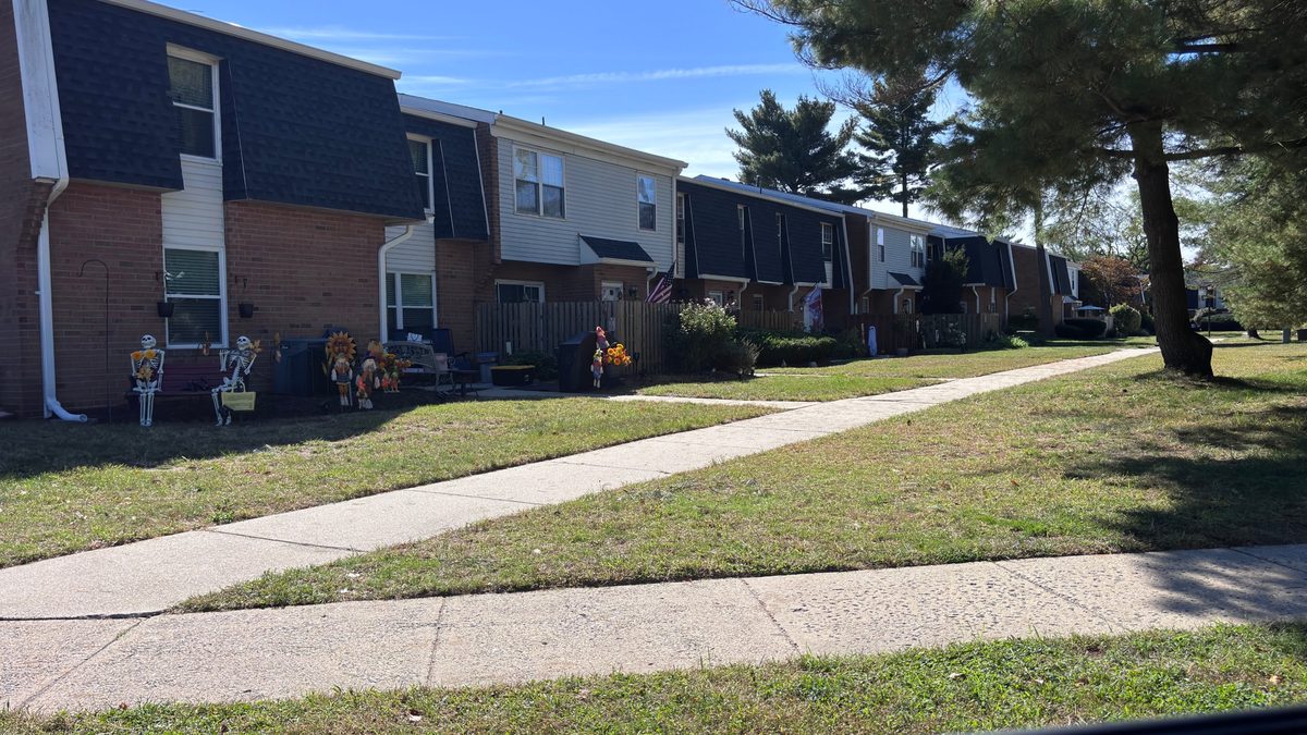 Palmyra Harbour townhomes with brick and siding fronts and a sidewalk through the lawn