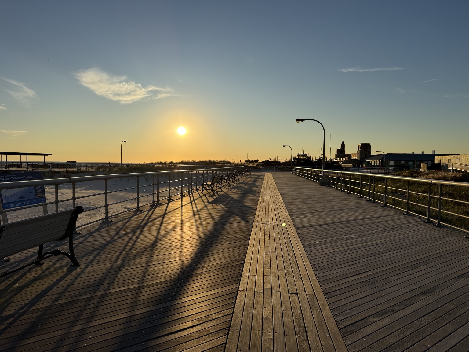 Golden evening light and long shadows across the central Jones Beach boardwalk on Long Island
