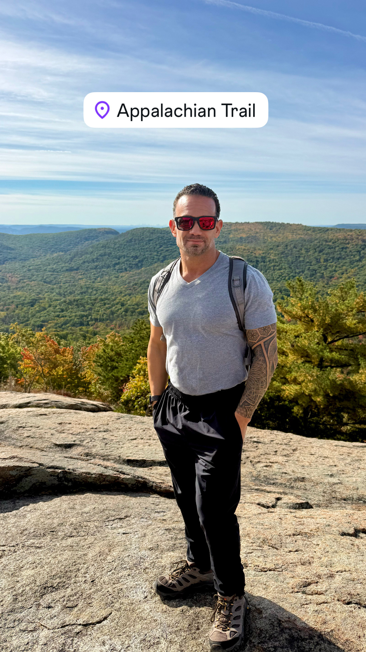 John Cordeira photographed on a rocky Appalachian Trail overlook during a Bear Mountain hike
