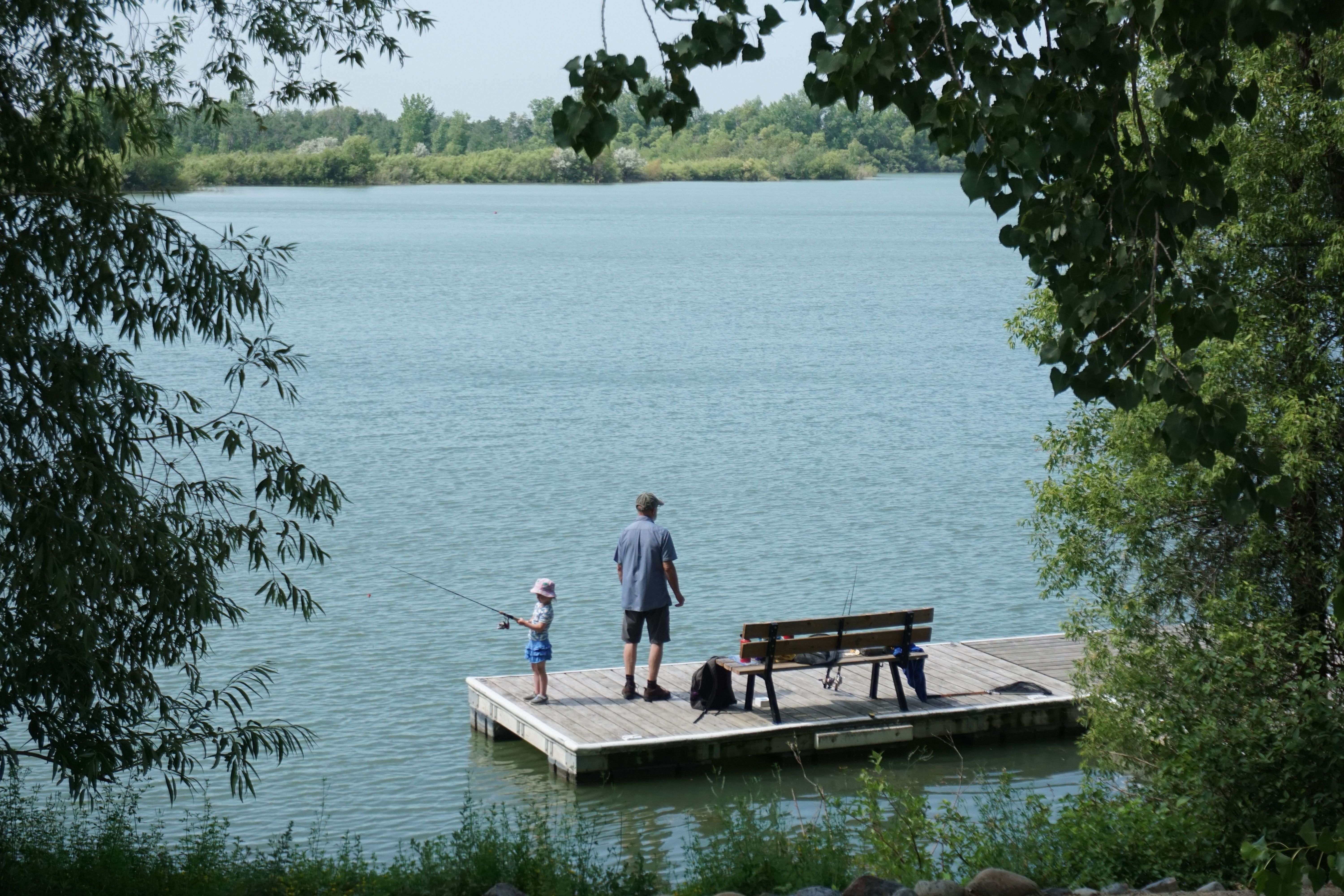 a man fishing with his daughter on a dock