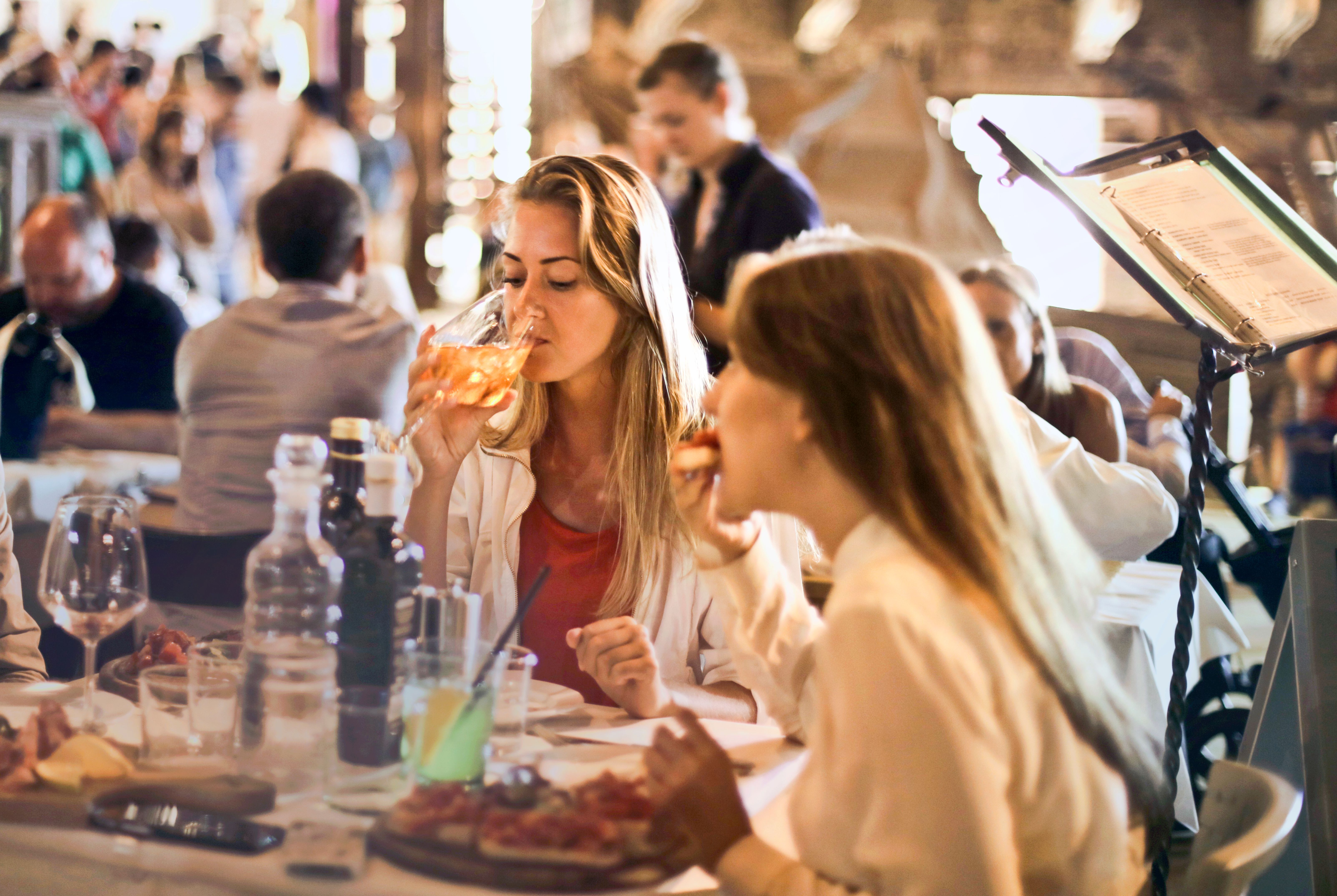 a woman driking wine inside a restaurant