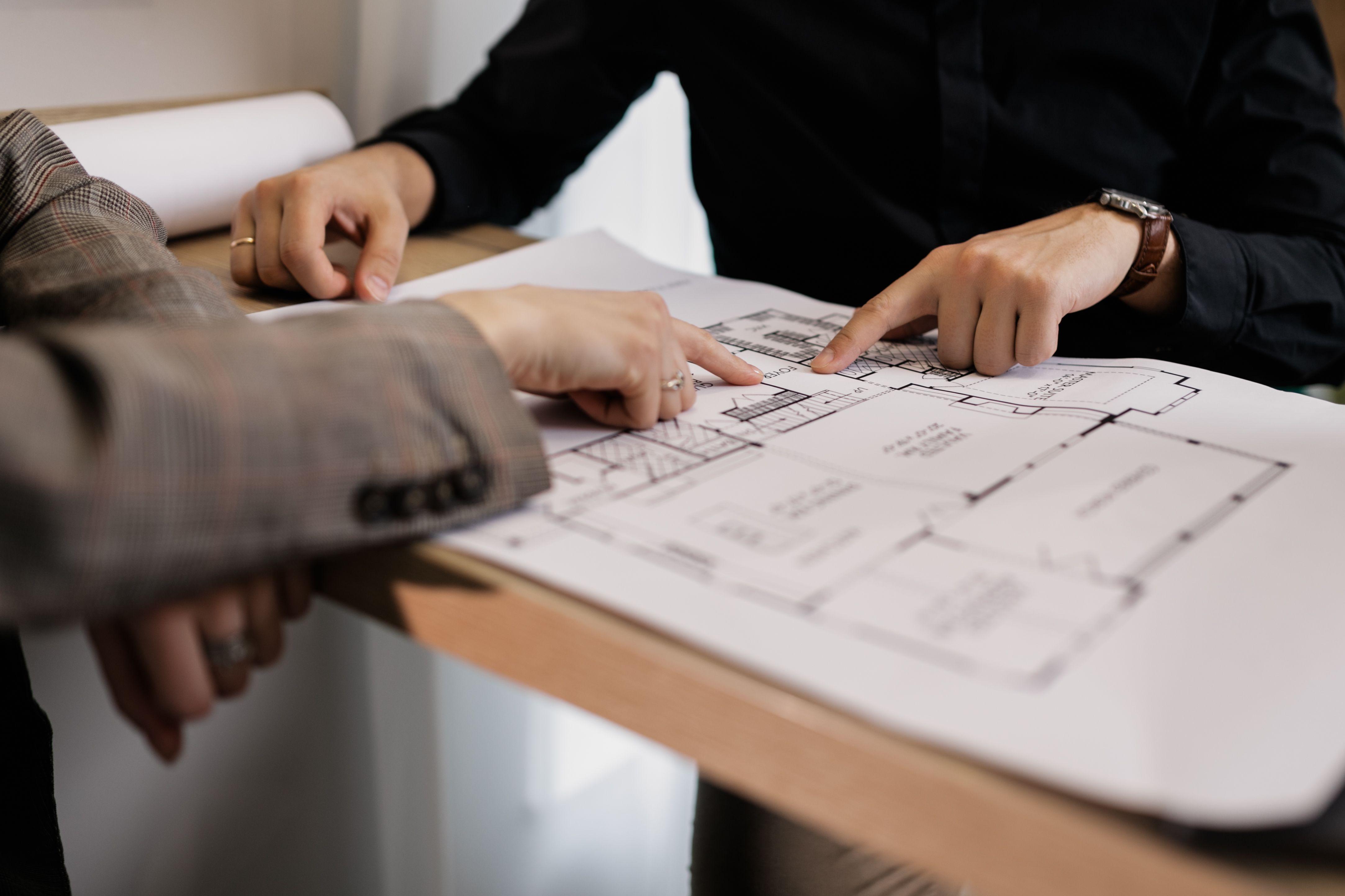 people pointing at a floor plan