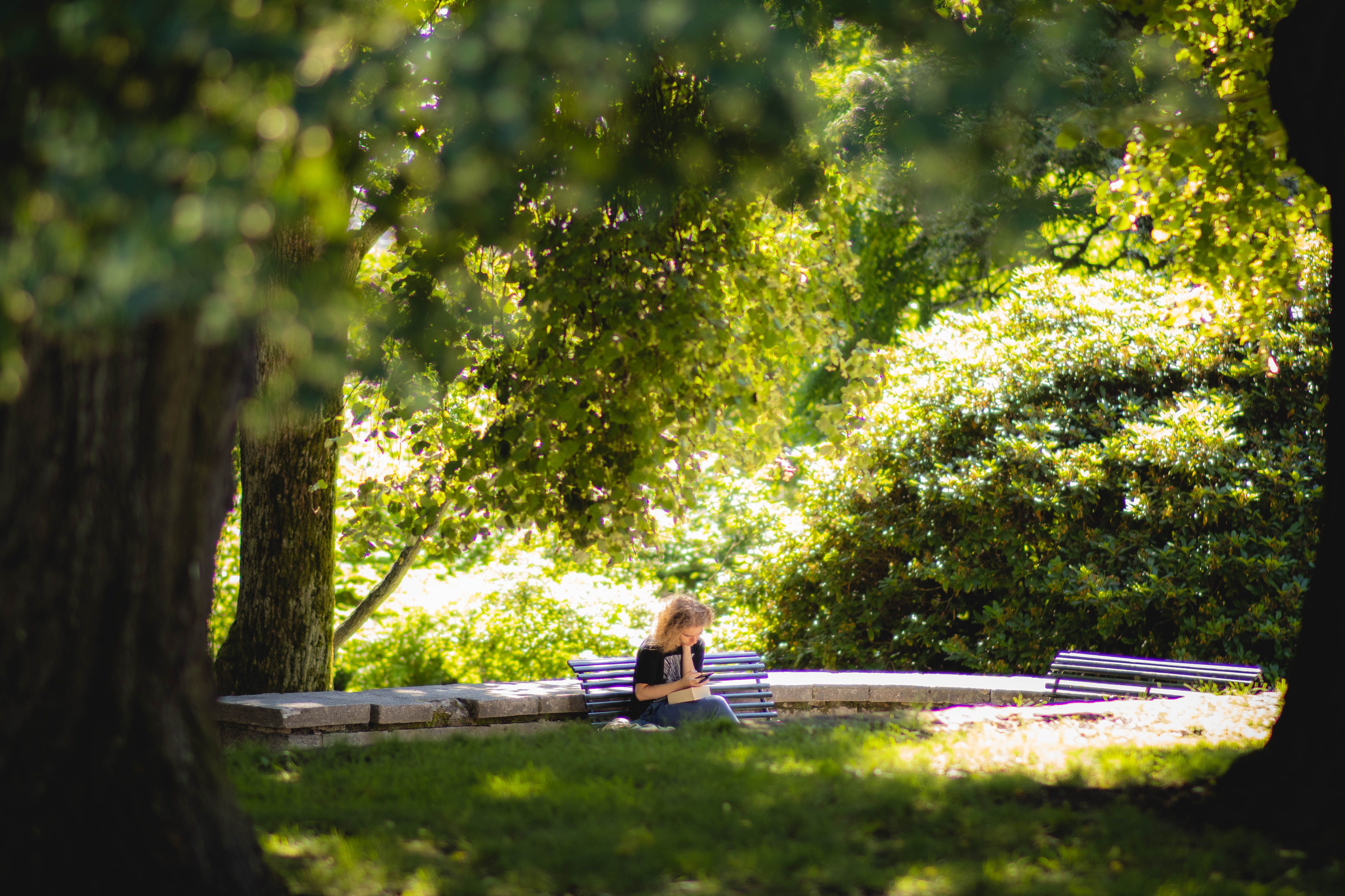 a woman sitting on a bench at the park