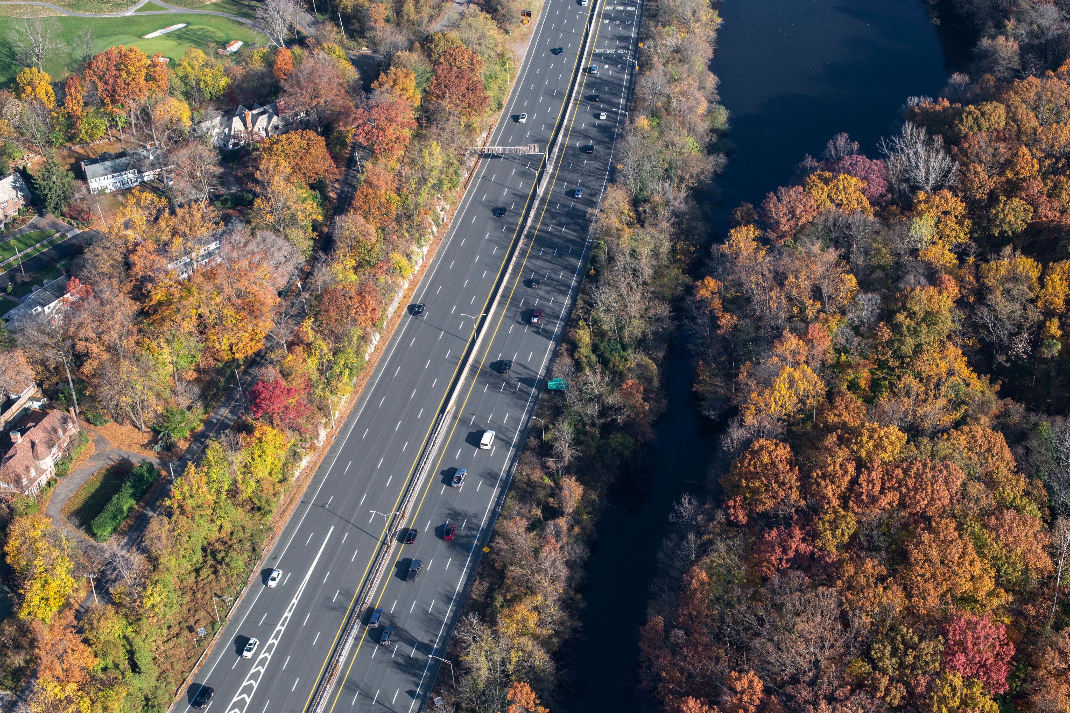 an aerial view of a freeway with cars and trees on the side