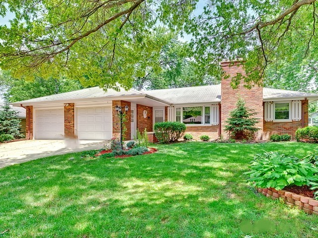 Brick ranch home with a front lawn, typical of houses families inherit.