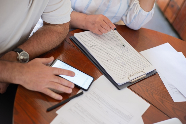 Home sellers reviewing paperwork and records at a kitchen table before listing.