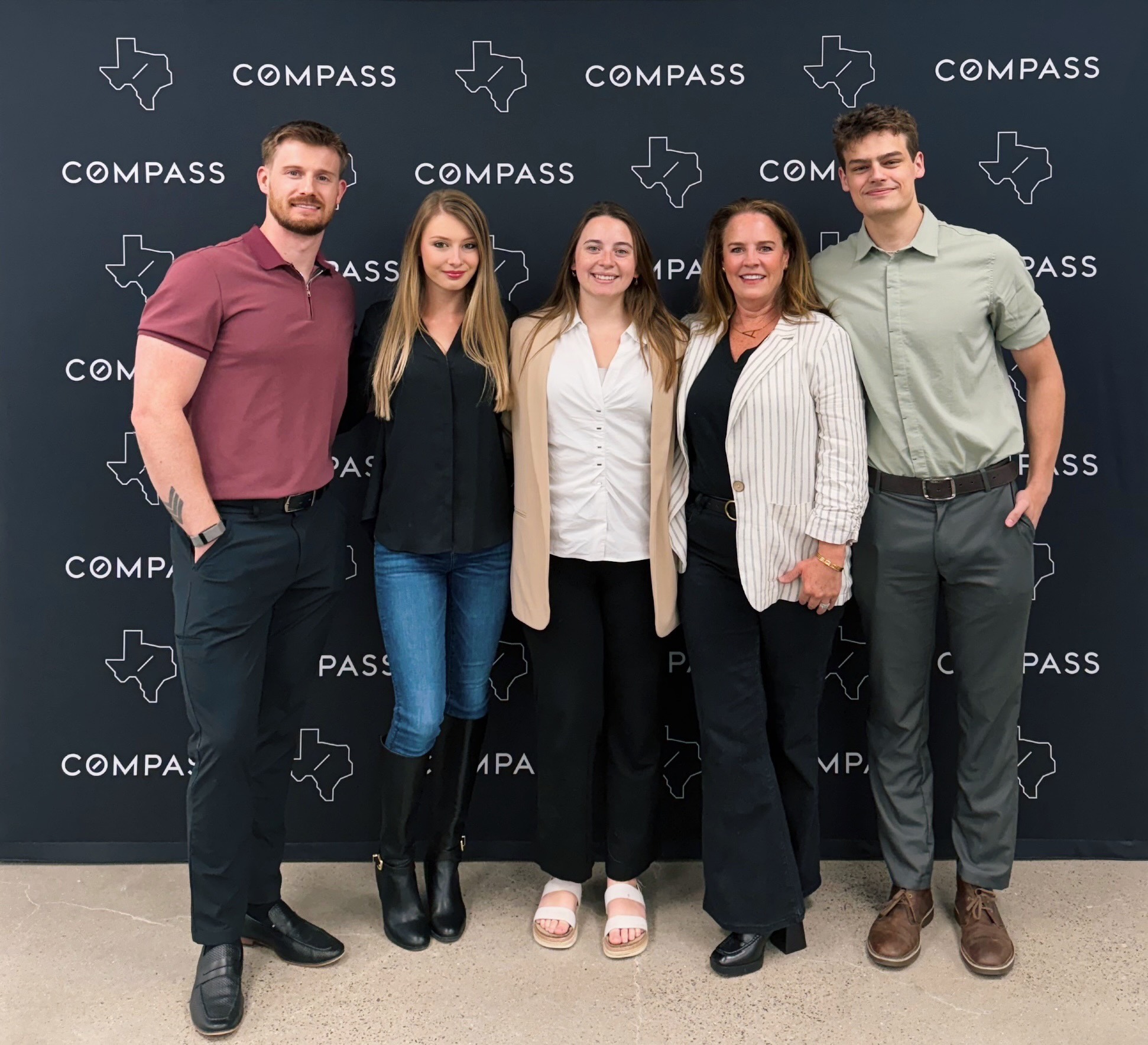 Kindred team members together in front of a Compass backdrop