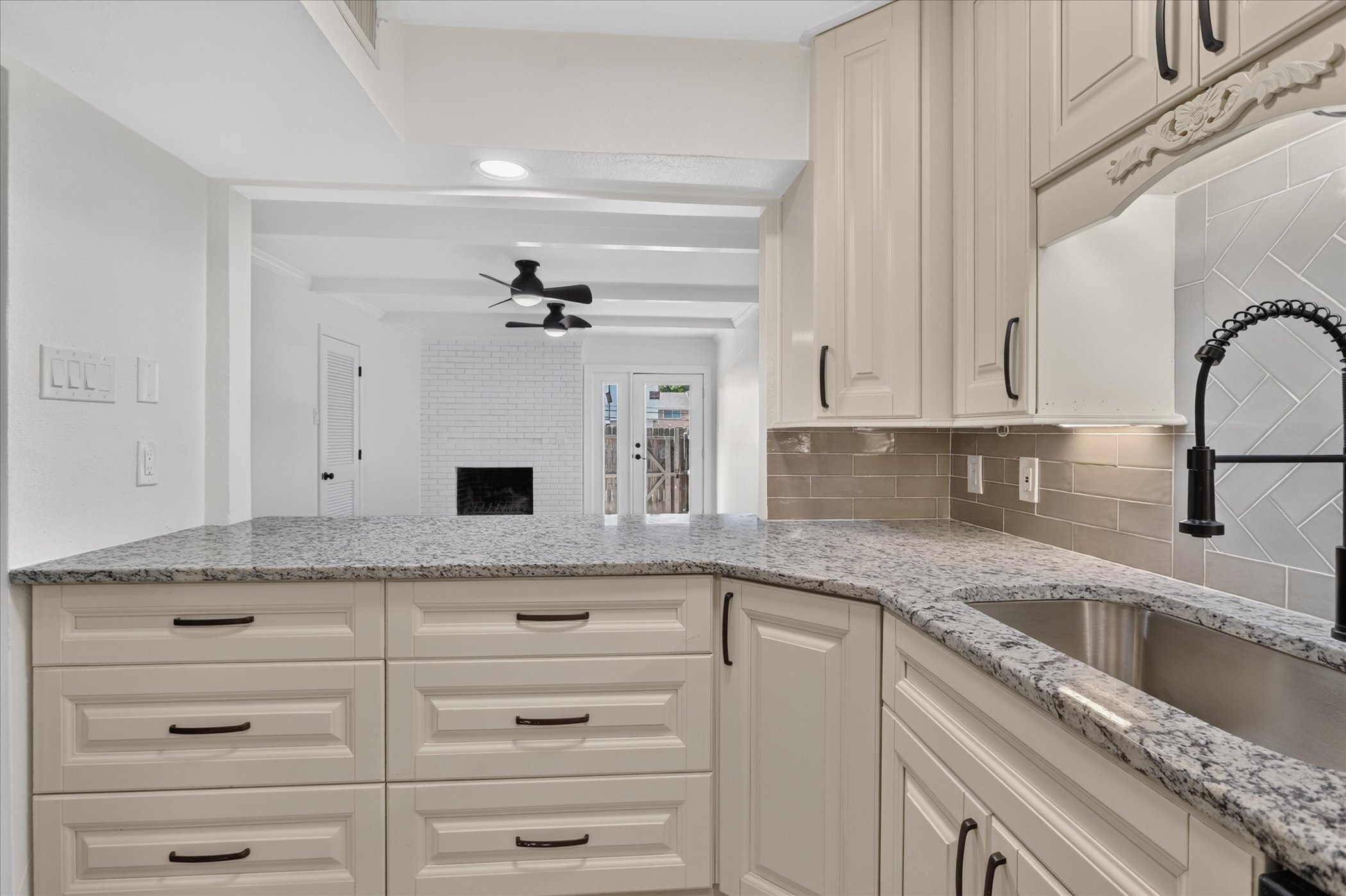 Renovated kitchen with granite counters and herringbone backsplash at 6020 E University Blvd Unit 117 Dallas