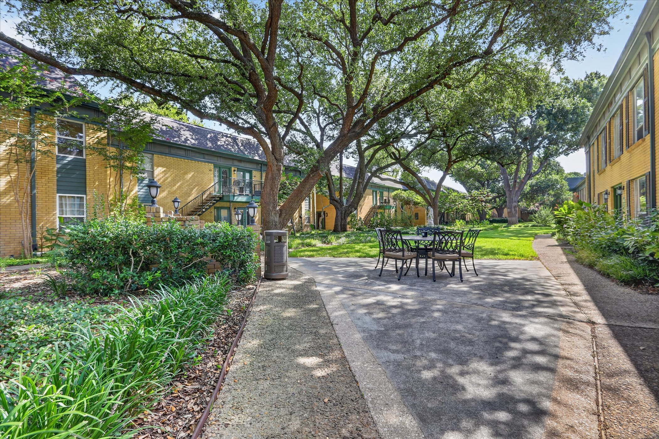 Tree-lined courtyard with mature live oaks at 6020 E University Blvd Unit 117 Dallas