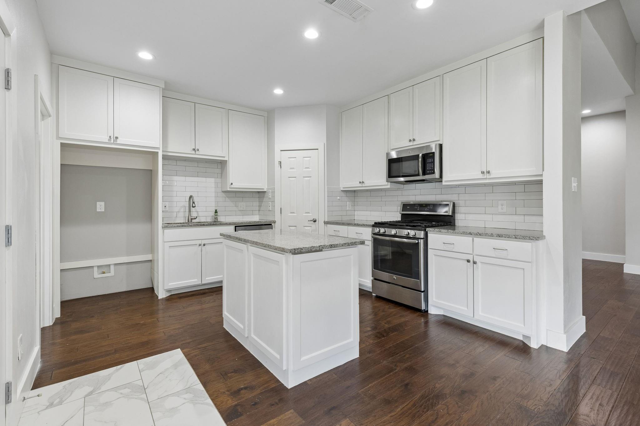 Updated kitchen with white cabinets and granite countertops at 7406 Bayview Drive