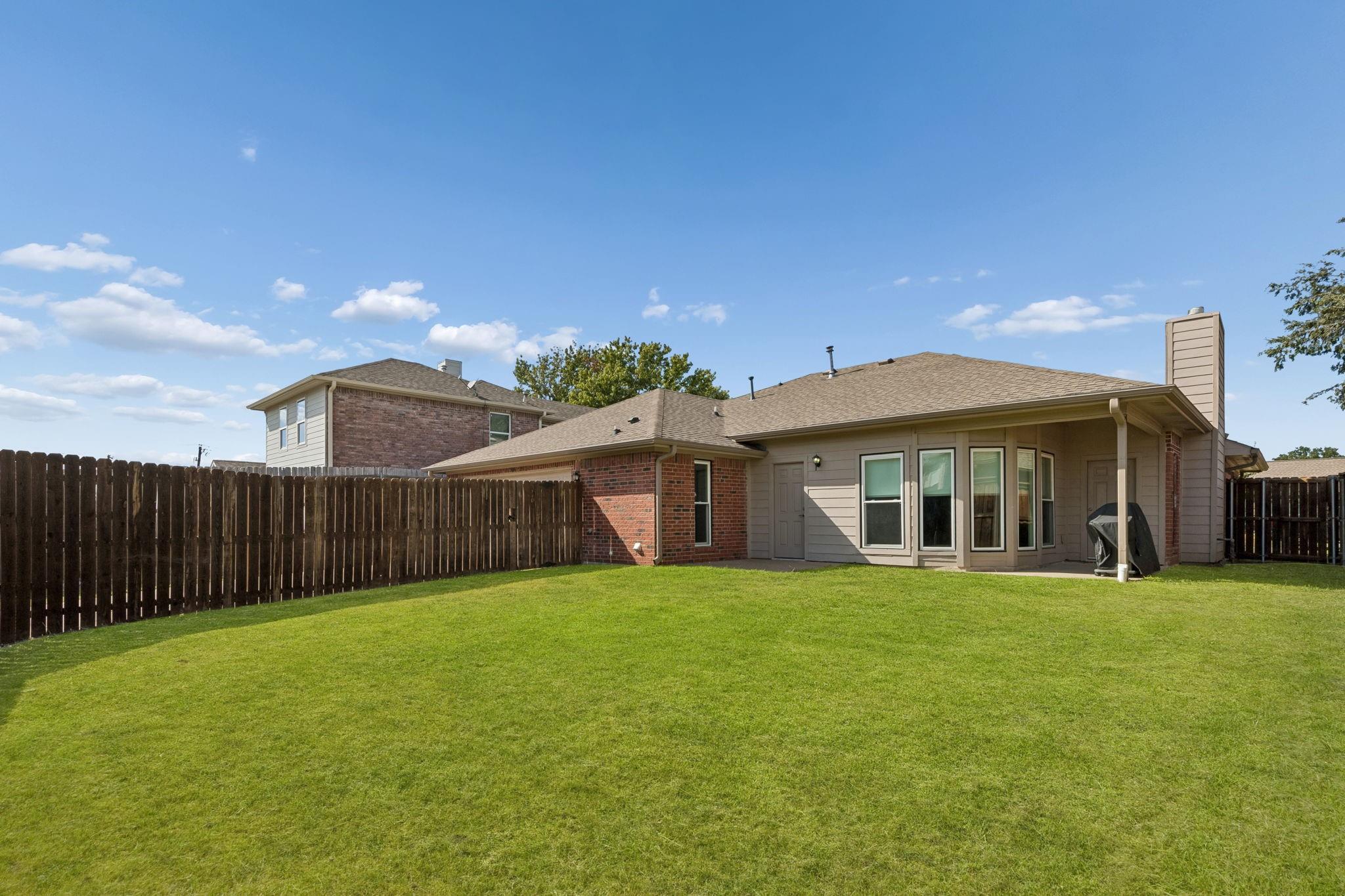 Spacious fenced backyard with covered patio at 7406 Bayview Drive Rowlett TX