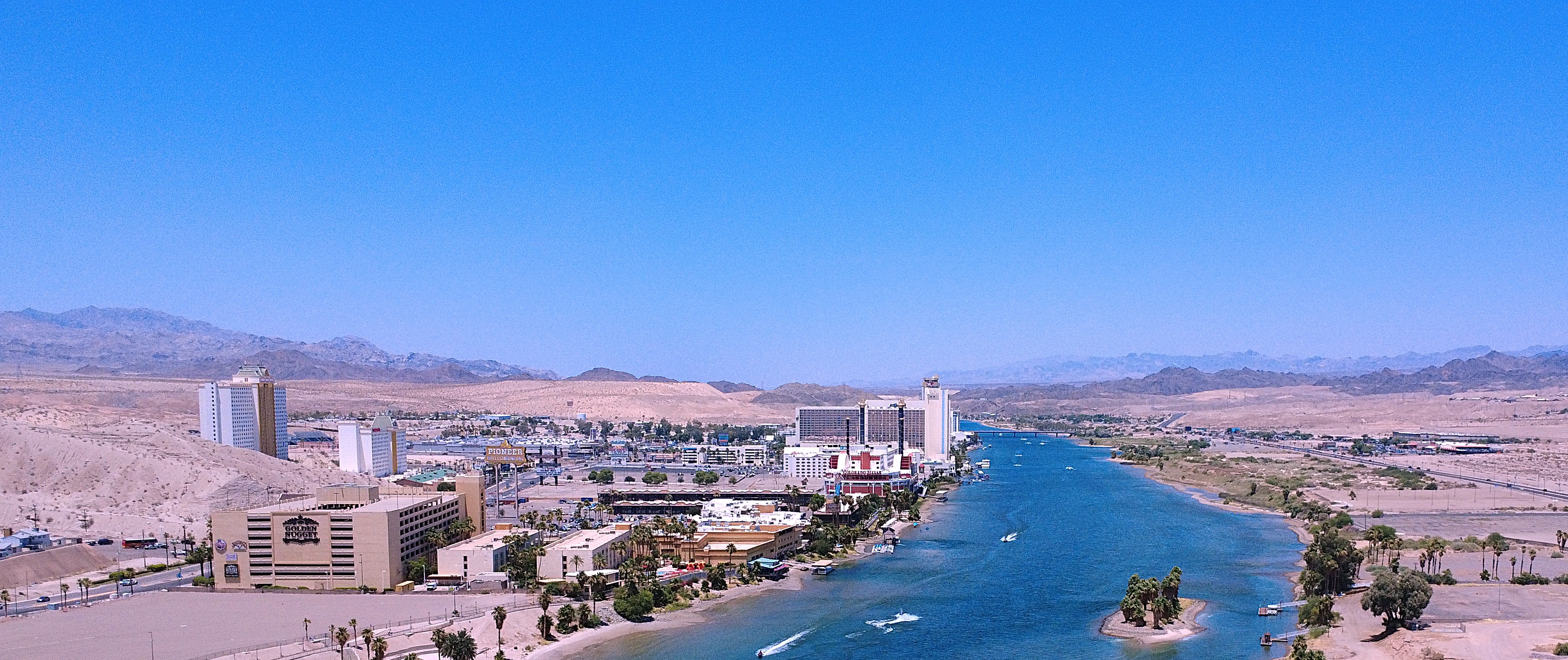 RV by a river with desert mountains