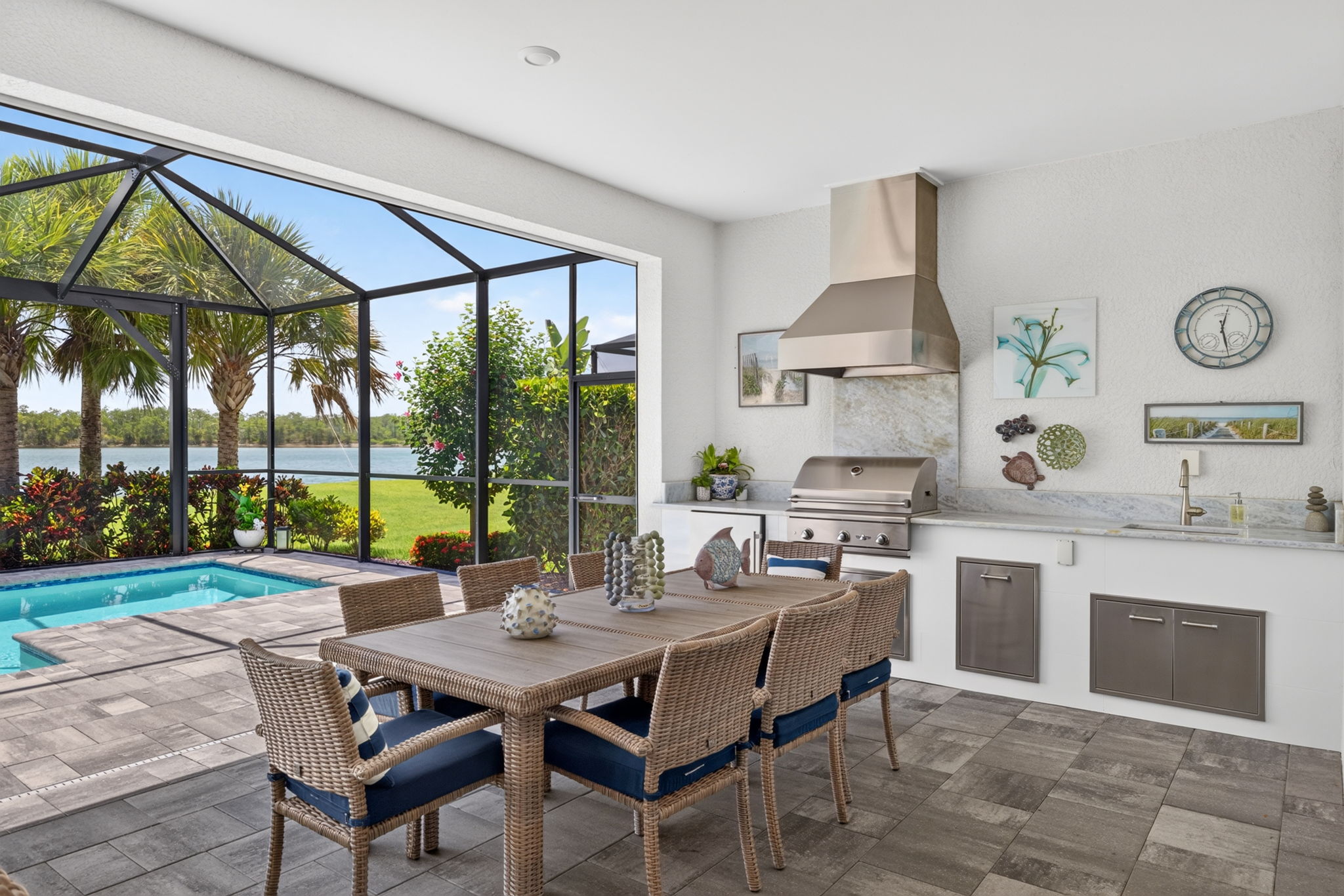Covered lanai with a summer kitchen, grill and outdoor dining beside the pool