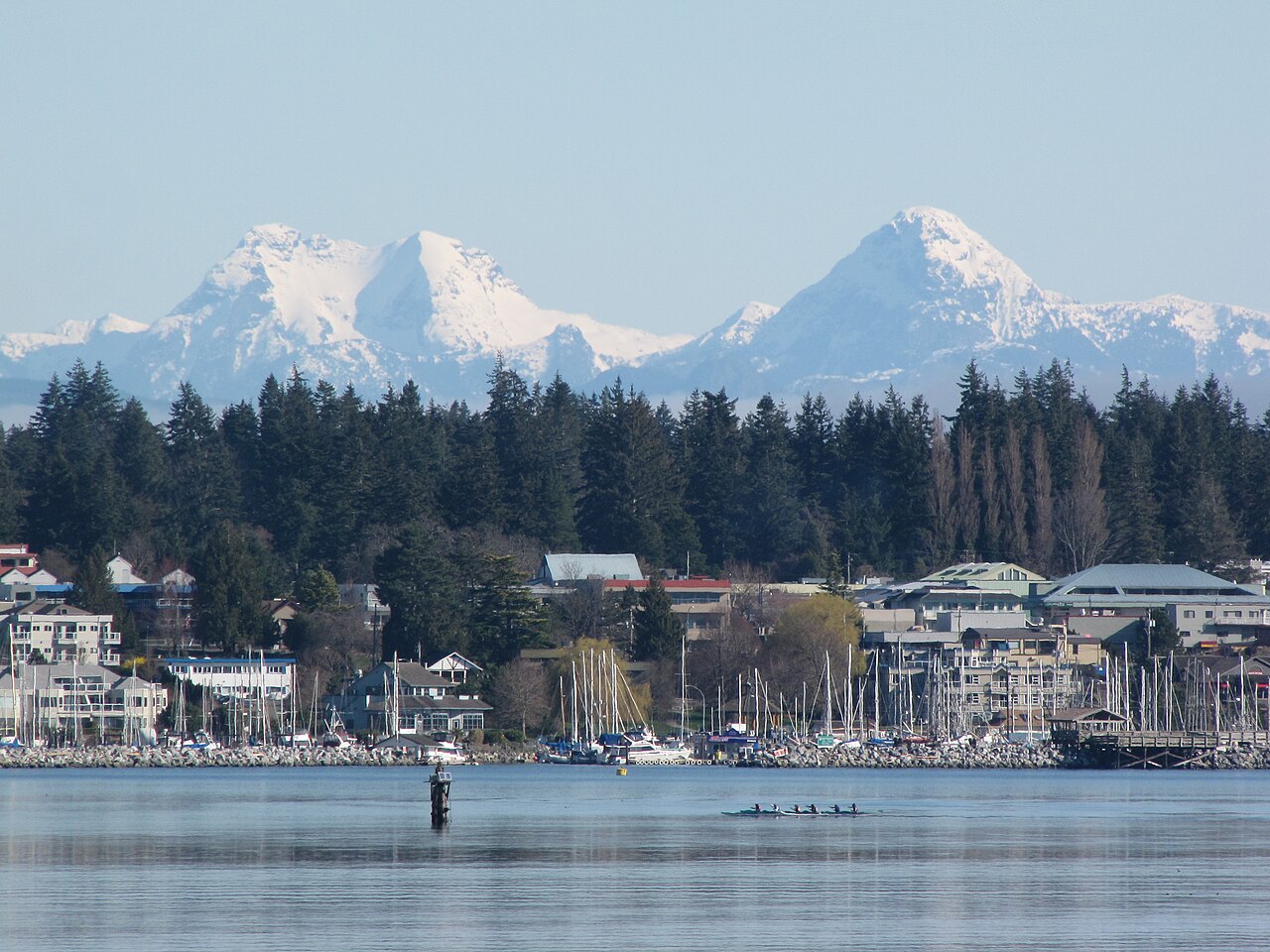 Comox marina and waterfront with snow-capped mountains rising behind the town