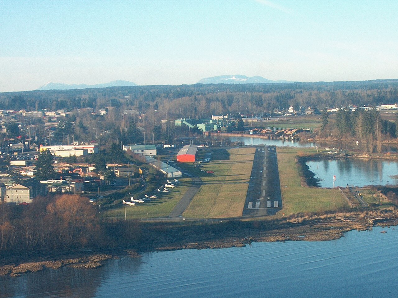 Aerial view of Courtenay homes, the airpark and the river estuary with mountains beyond