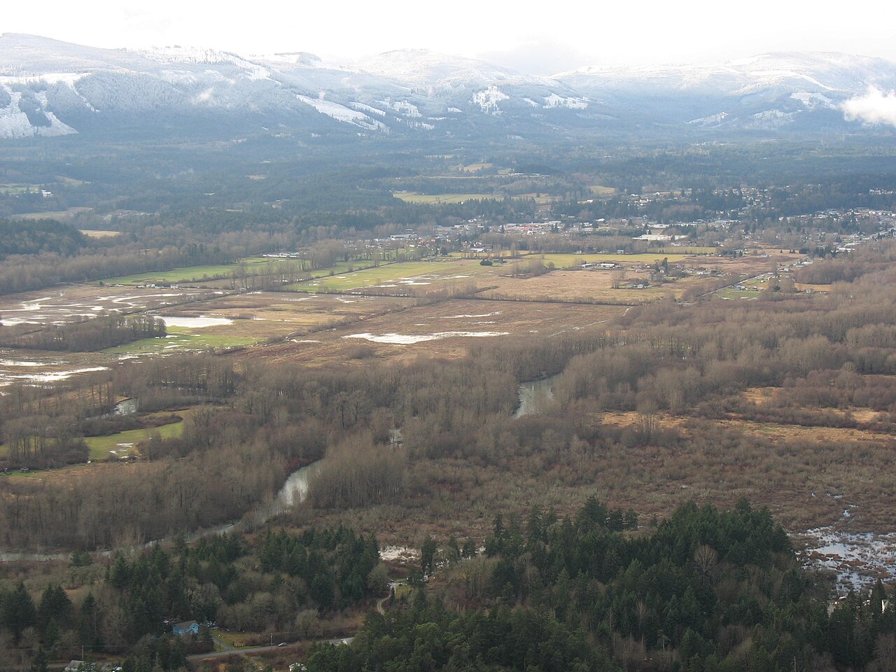 Farm fields and woodland in the Cowichan Valley near Duncan with snowy hills beyond
