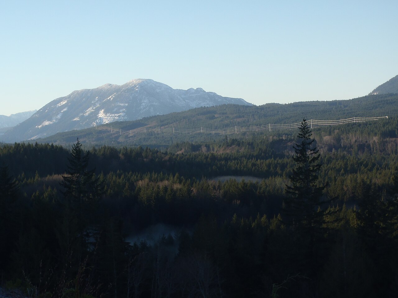 Forested rural hills and a snow-dusted mountain south of Nanaimo