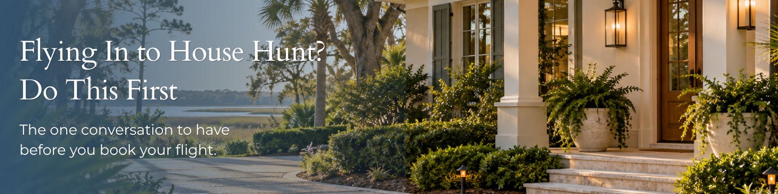 Warm evening light on a Hilton Head home's front entrance, with a marsh view down the walkway, lush landscaping, and lantern-lit porch details