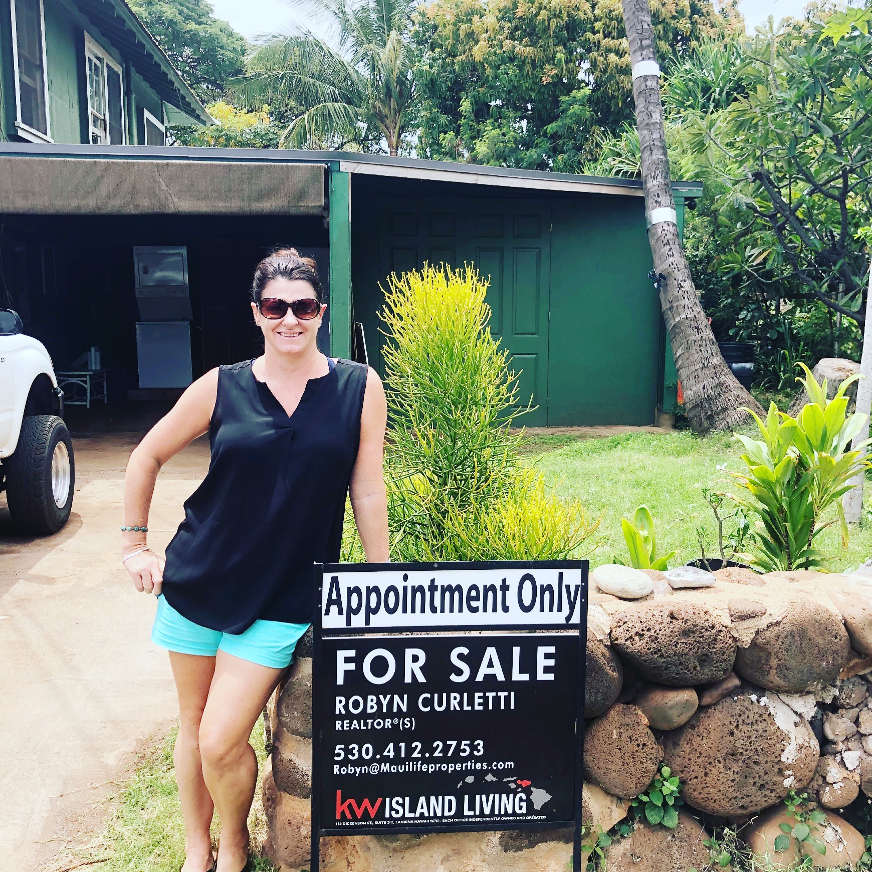 Robyn standing beside a "For Sale" sign | Lahaina homes for sale
