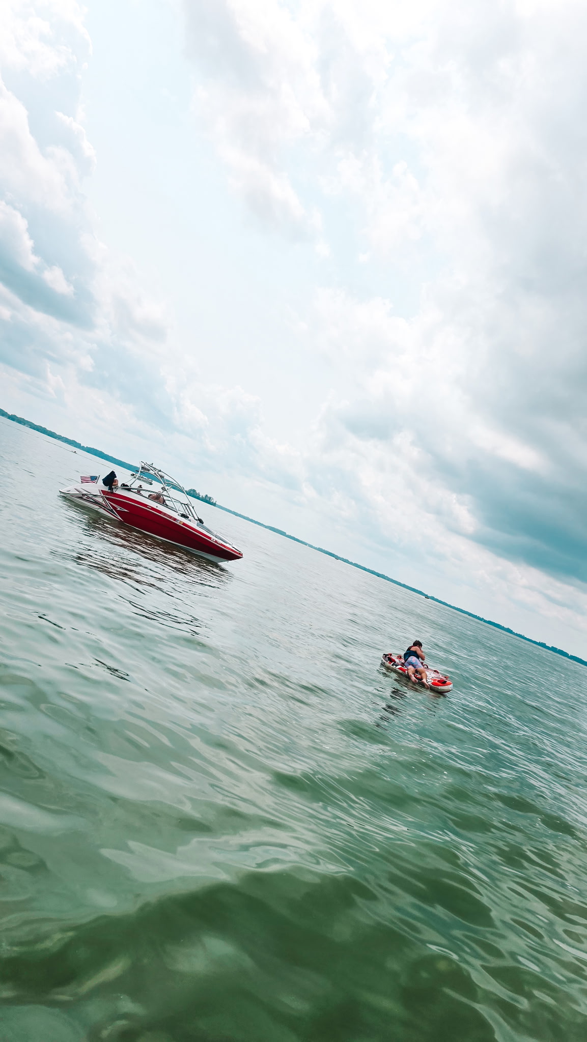 Red motorboat and people enjoying watersports on Grand Lake St. Marys
