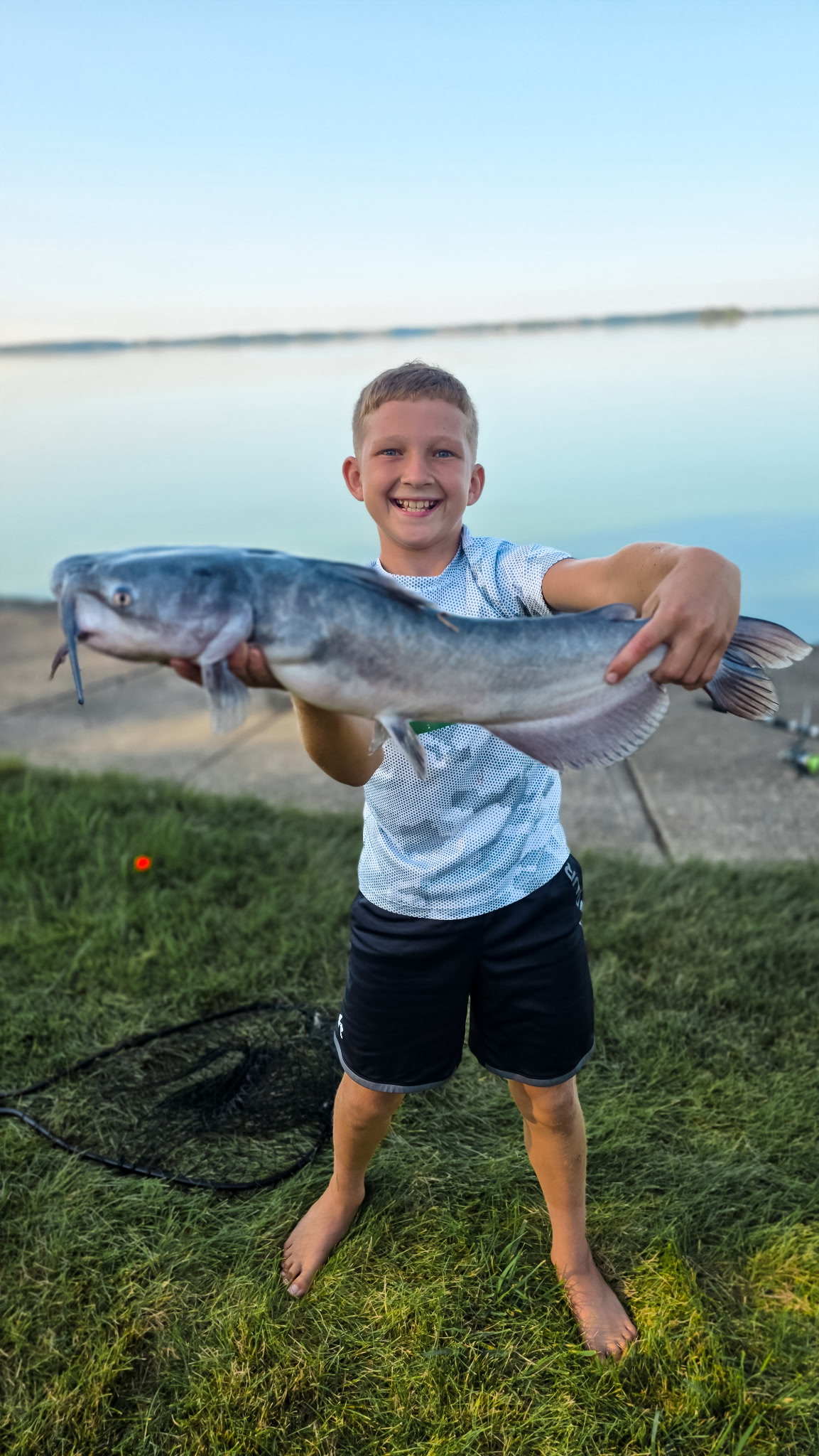 Young angler proudly holding a large catfish caught at Grand Lake St. Marys