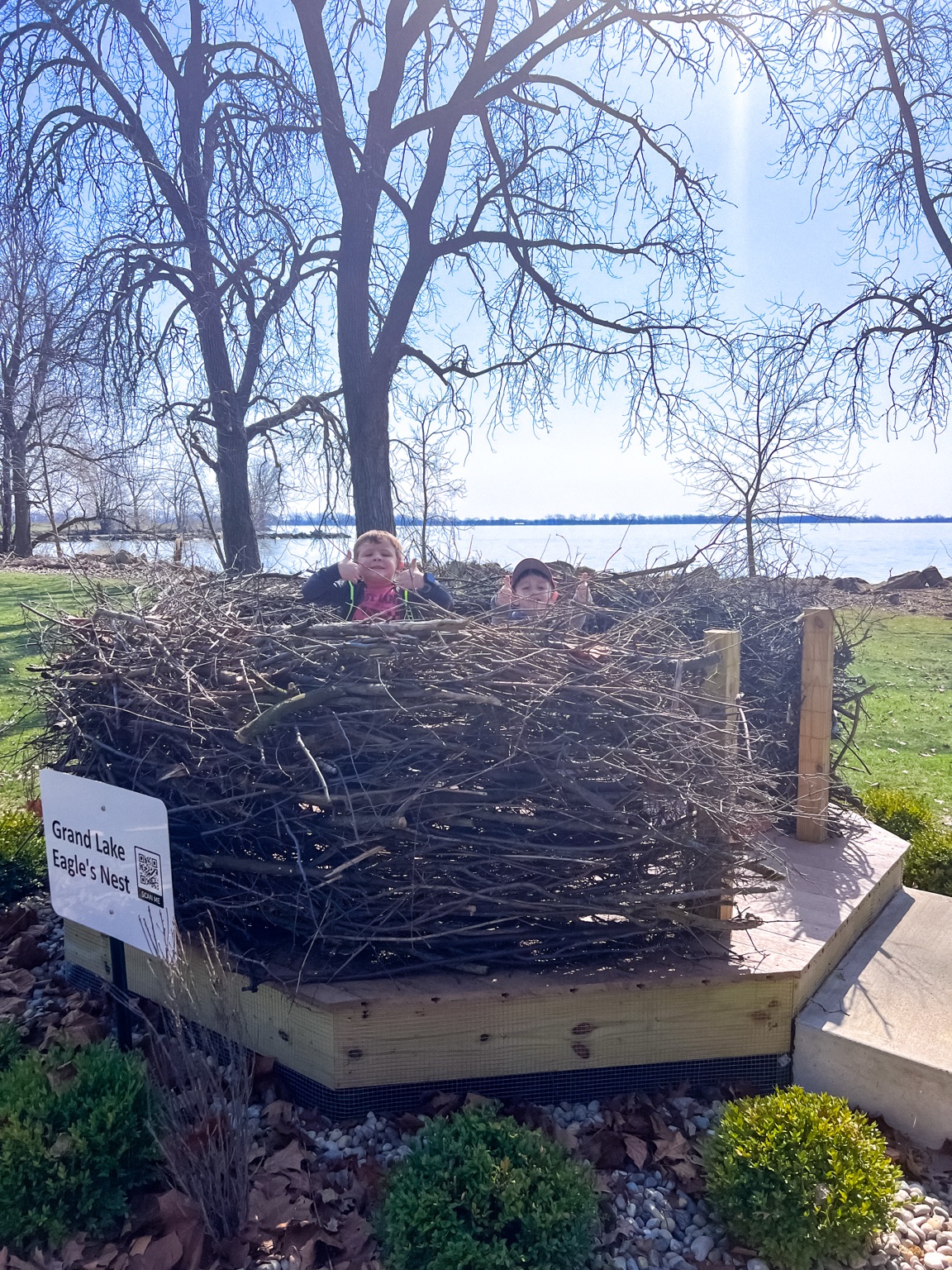 Children peeking out of the giant Grand Lake Eagle's Nest display beside Grand Lake St. Marys