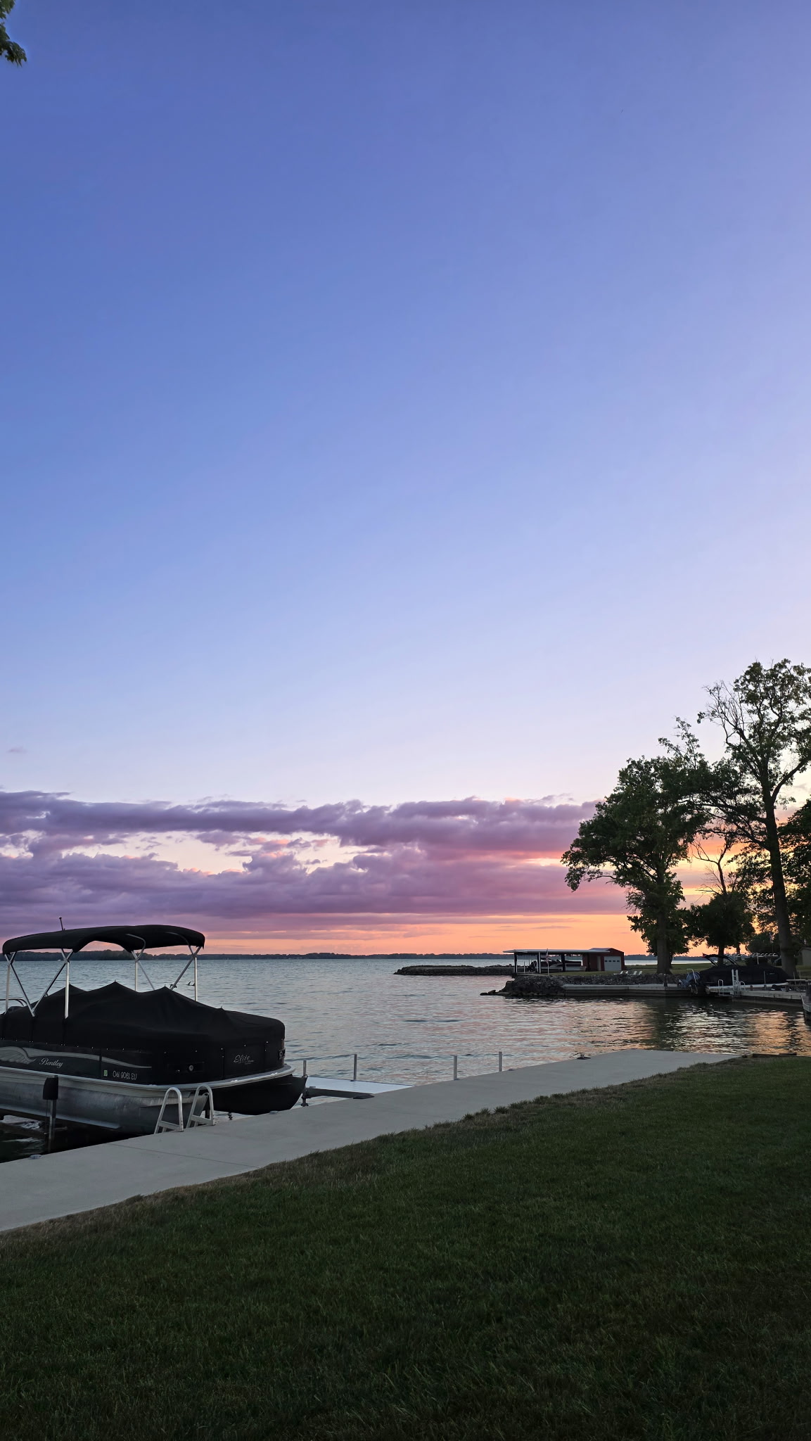 Pontoon boat docked on Grand Lake St. Marys under a pastel sunset