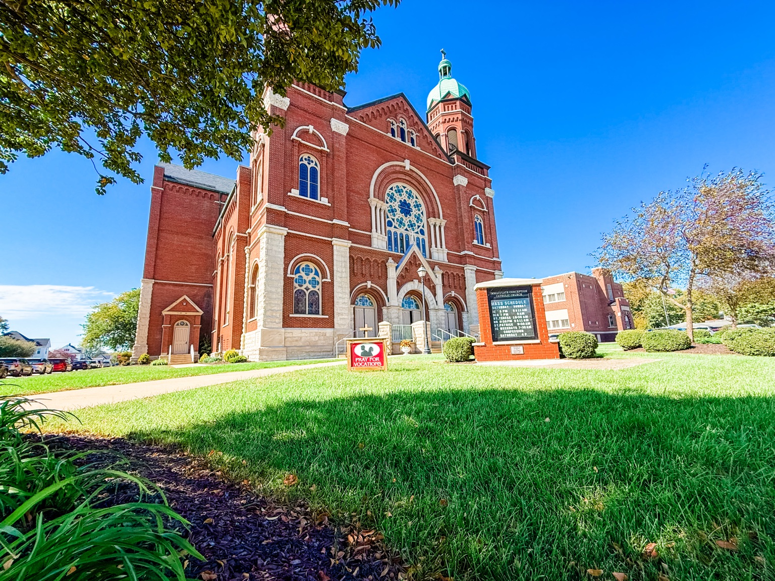 Angled view of Immaculate Conception Church in Celina Ohio showing its side elevation and brick architecture