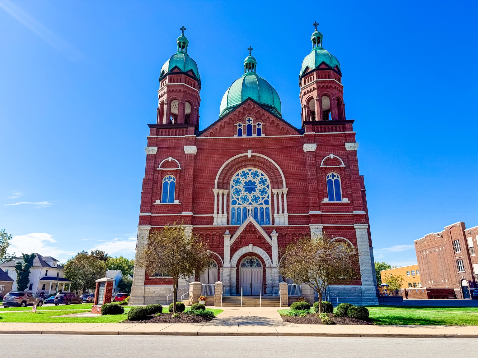 Frontal view of Immaculate Conception Catholic Church in Celina Ohio with twin towers and three green domes