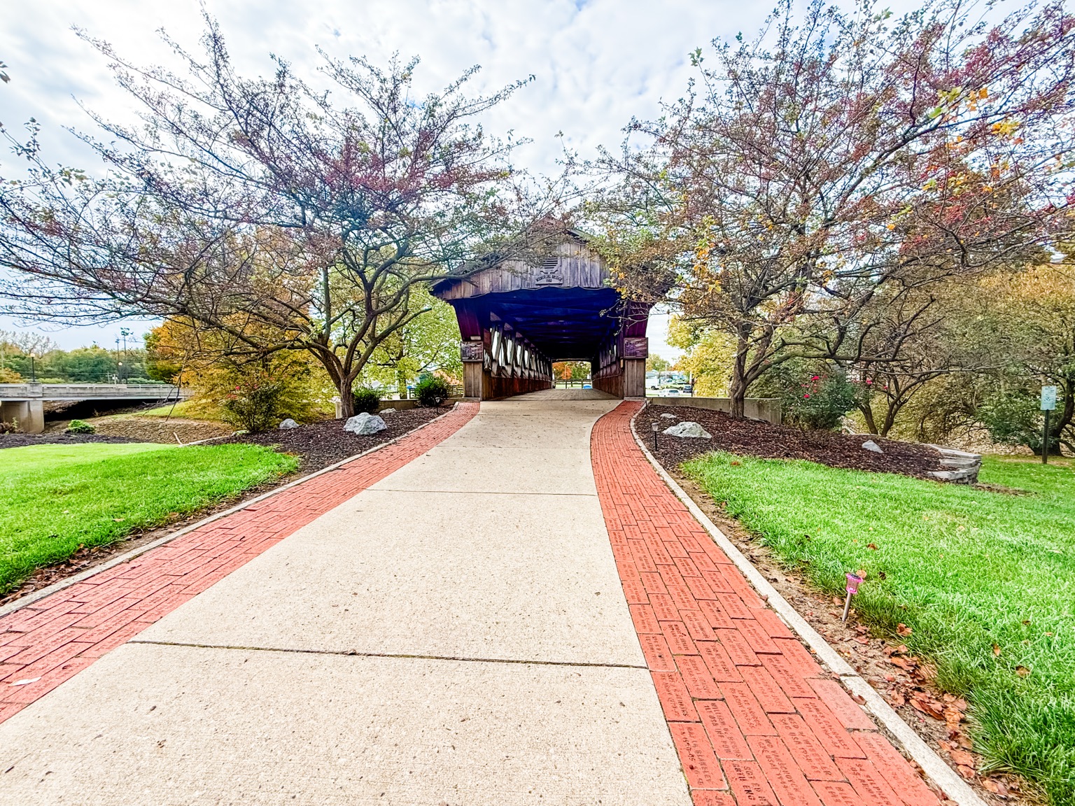 Covered pedestrian bridge framed by autumn trees in St. Marys Ohio