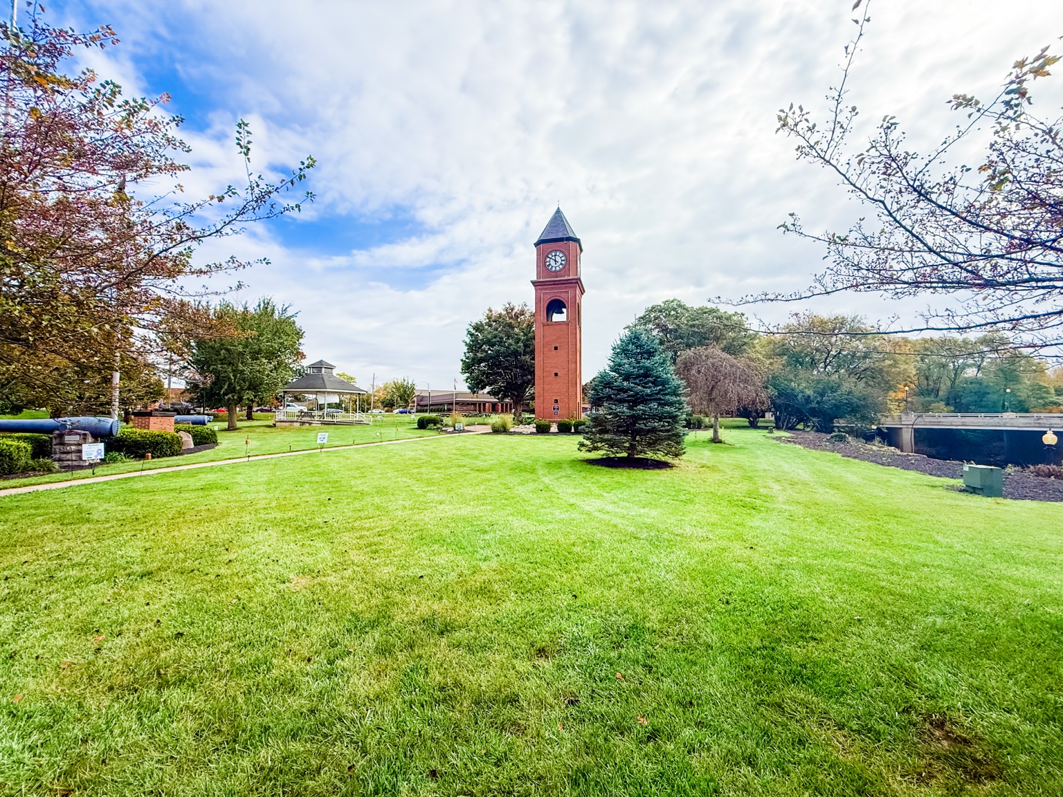 Wide green park with red brick memorial clock tower in St. Marys