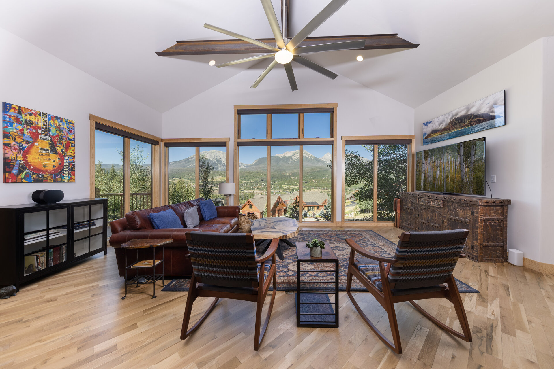 Living and dining area with a wall of windows to the Gore Range