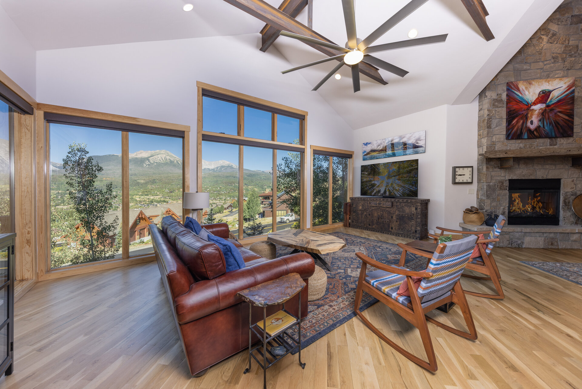 Vaulted great room with stone fireplace and mountain views