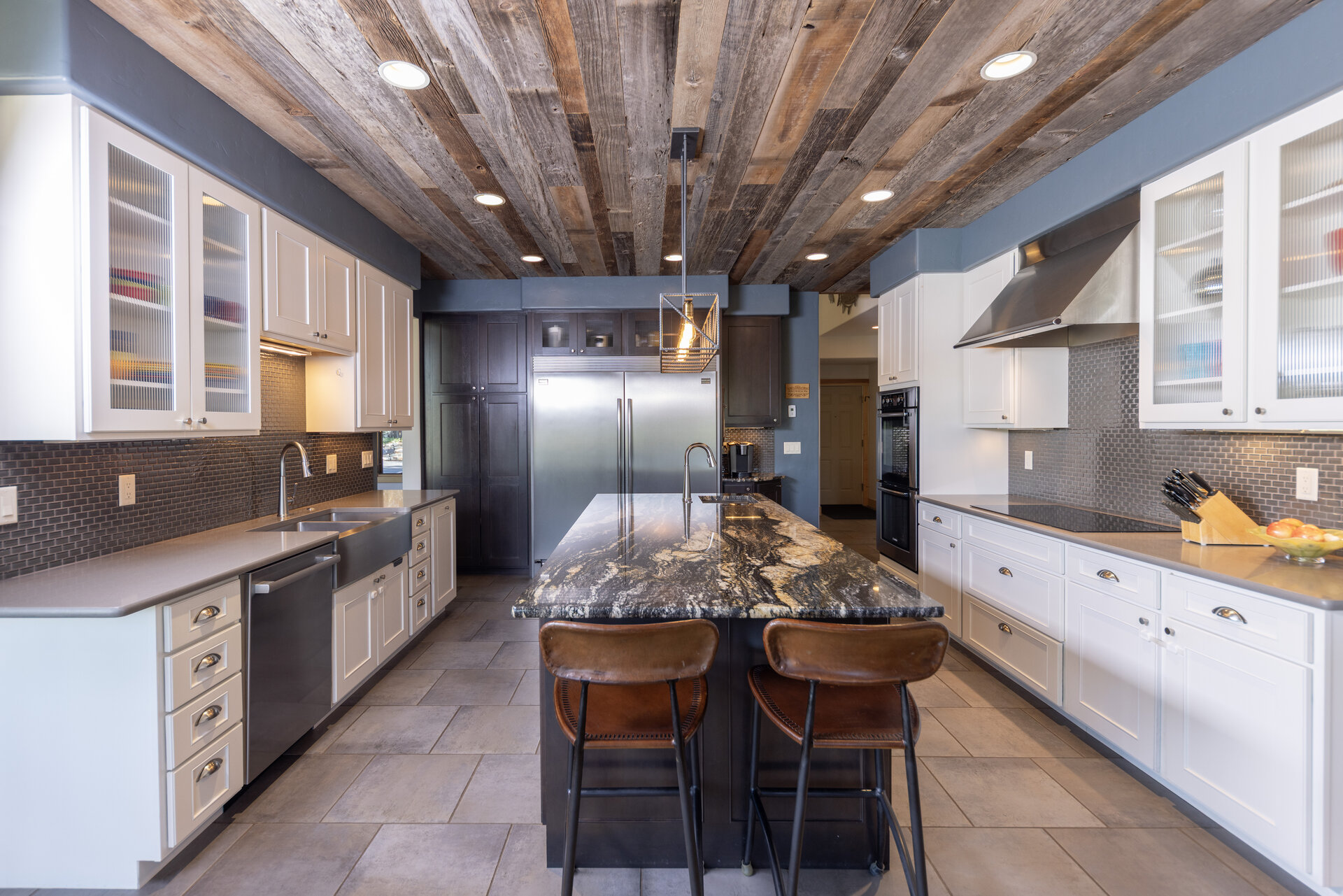 Kitchen with large island, stone counters and reclaimed wood ceiling