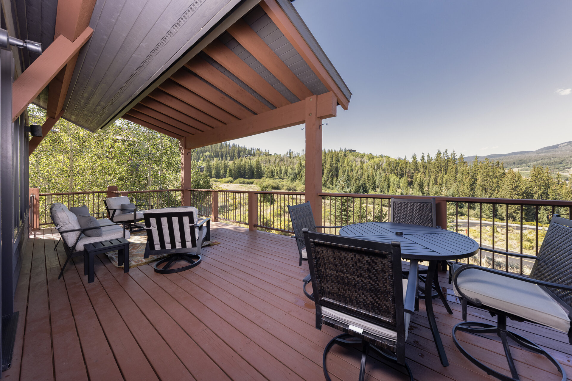 Covered deck with outdoor seating and forest views
